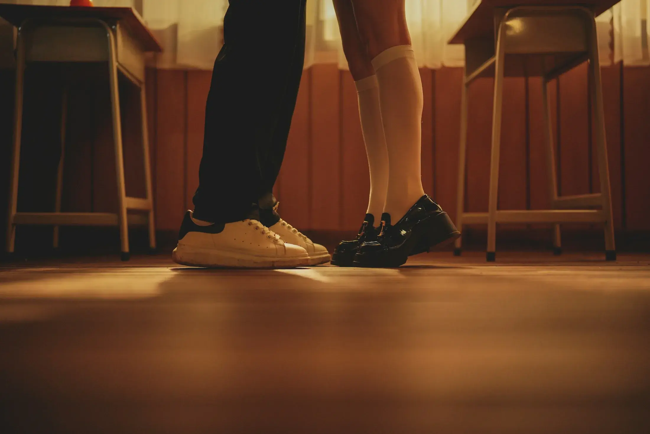 Close view of a couple's feet on a wooden floor