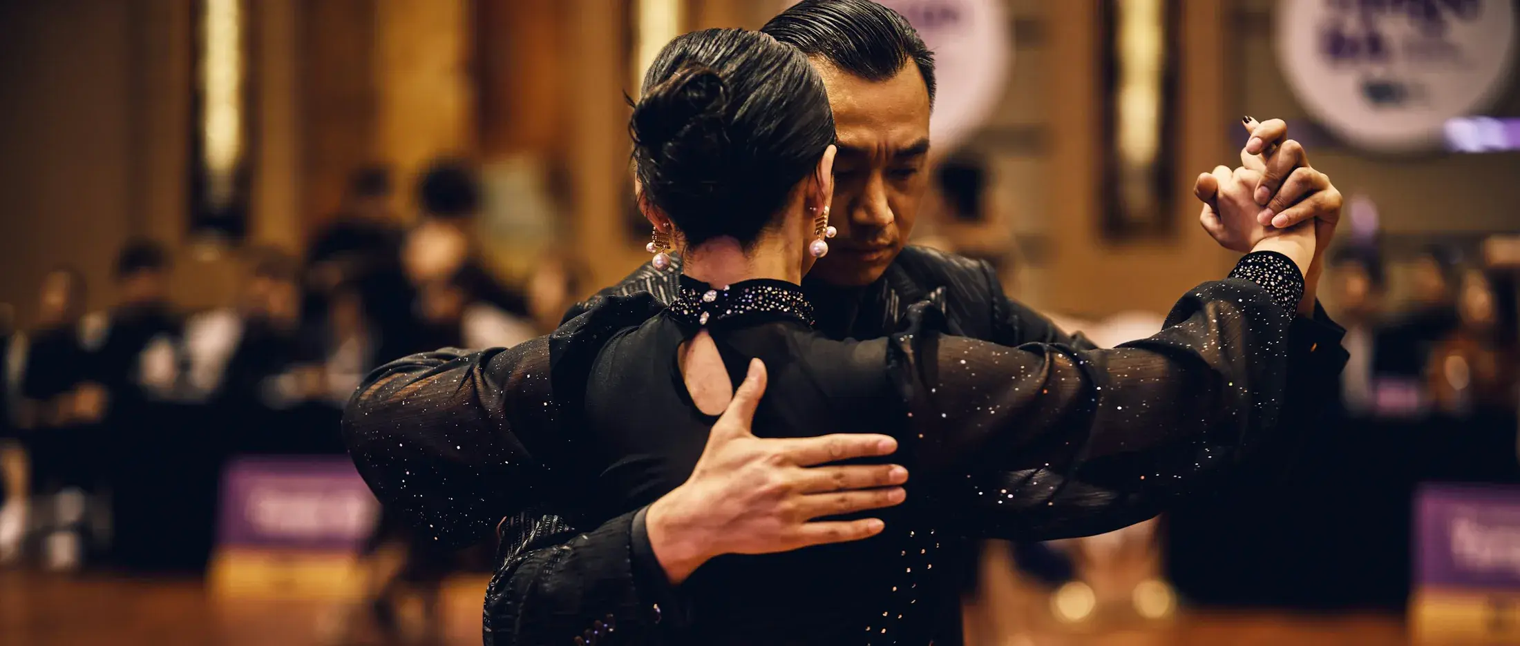 A ballroom couple in formal dress in a close hold
