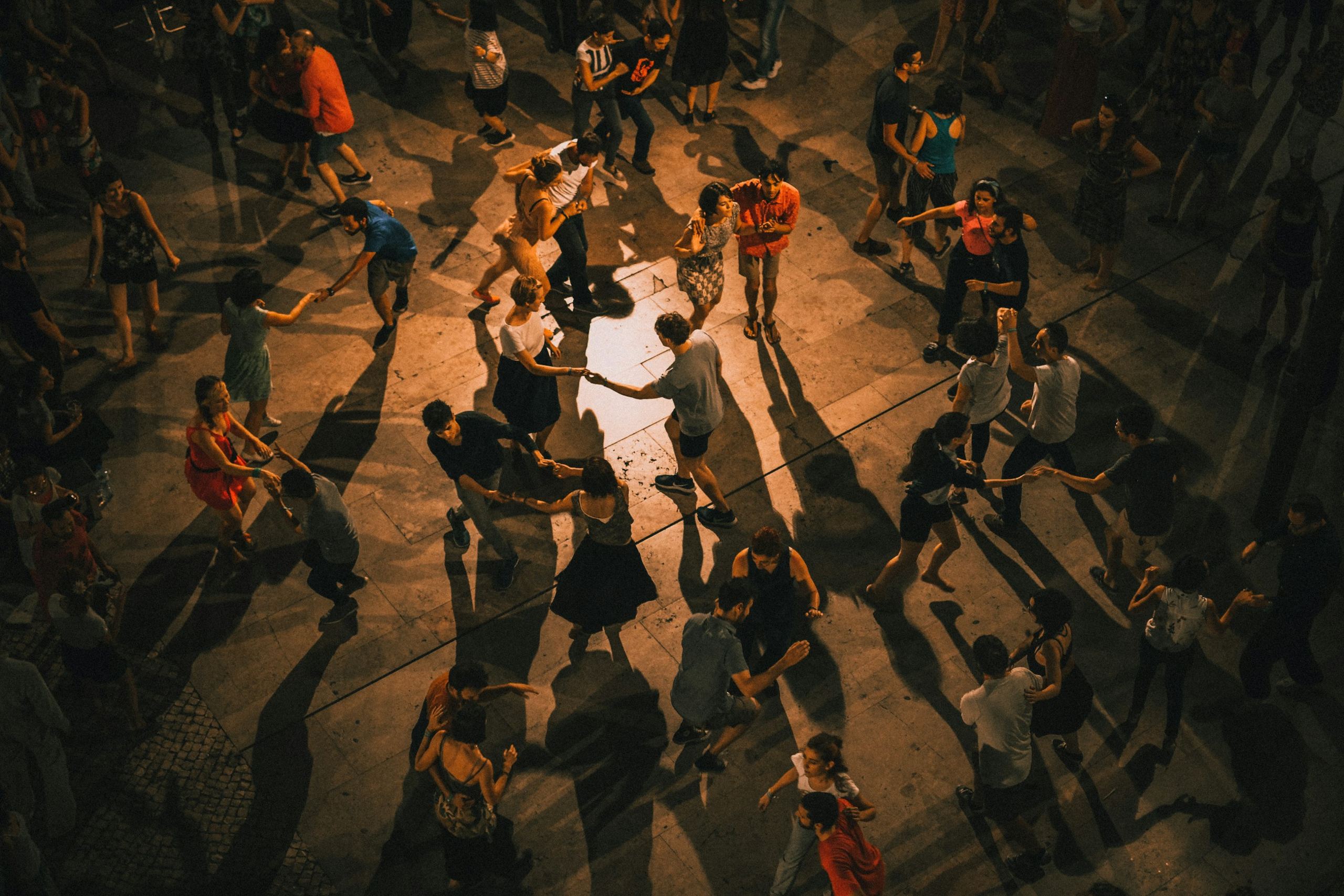 Couples social dancing on an open outdoor plaza