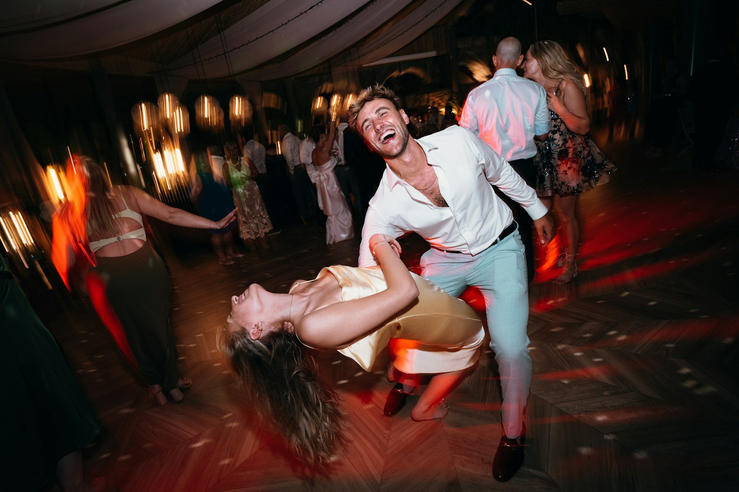 A couple dancing joyfully at an outdoor celebration